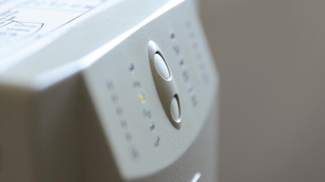 Turning on uninterruptible power supply. Pressing button initiates power-up sequence, and status indicators flash to confirm UPS is operational 