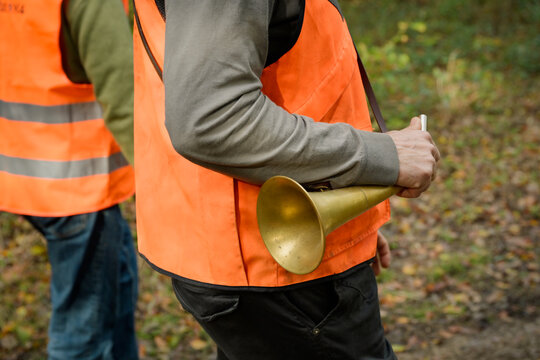 Cadrage serr&eacute; sur la main d'un homme &agrave; la chasse qui tient une pibole ronde, instrument d'appel en v&eacute;nerie