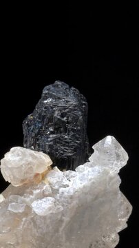 Wolframite or Hubnerite (manganese iron tungstate) on Jacare Quartz matrix (Brazil) rotating slowly against a black background. Vertical