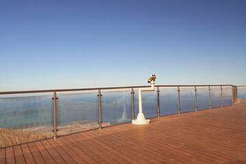 Obraz premium Arab man looking through the binocular at the top of Jabal Jais Mountain, United Arab Emirates.