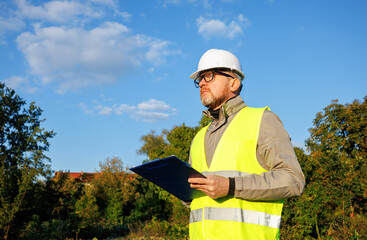 Male engineer inspects the condition of a new construction site. Work forestry inspector, environmental control. Ecologist conducts environmental monitoring soil analysis. 