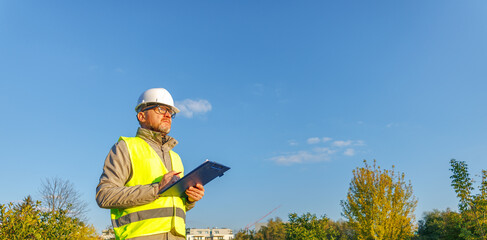 Male engineer inspects the condition of a new construction site. Work forestry inspector, environmental control. Ecologist conducts environmental monitoring soil analysis. 