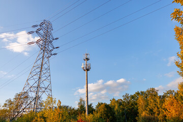 Tower gsm telecom network 5g and electro transmission lines against blue sky. Business electricity mobile technology.