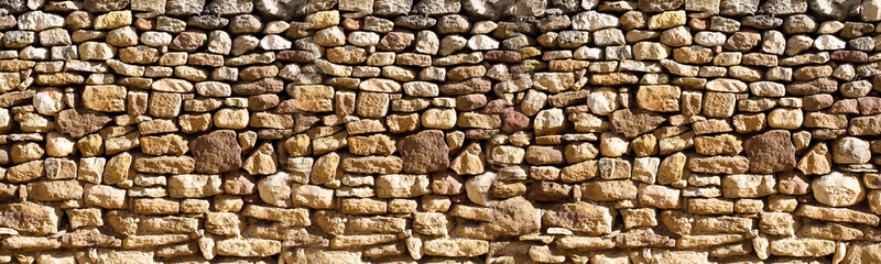 Rustic dry stone wall texture with natural earth tones. dry stone wall, showcasing irregular shapes and natural earthy colors. The texture is rough and organic.