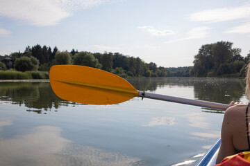Mother and daughter kayaking on calm river on a sunny summer day, enjoying outdoor adventure and family time together in nature