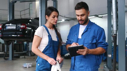 Auto repair shop employees are working together. Man and woman. - Powered by Adobe