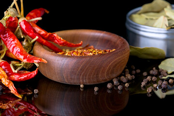 Spices and herbs, bay leaf, black pepper and wooden bowl of chili flakes