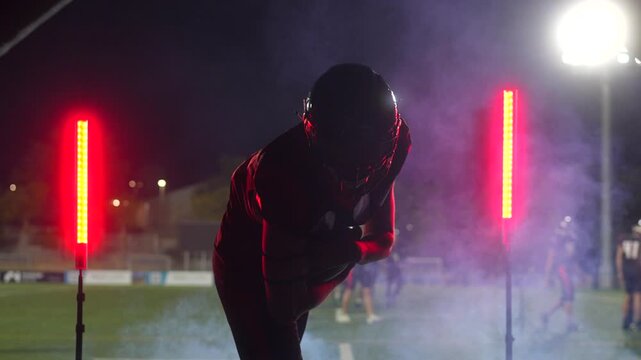 American football player celebrating touchdown at night