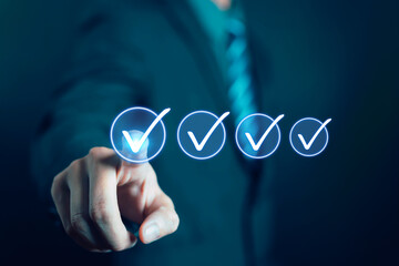 Businessman pressing virtual check marks on digital interface, concept for task completion, quality assurance, project management, success, and business goal achievement in modern technology.