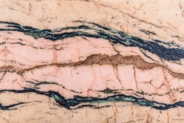 Fototapeta premium Banded rock with layers of pink, cream, green, and dark streaks