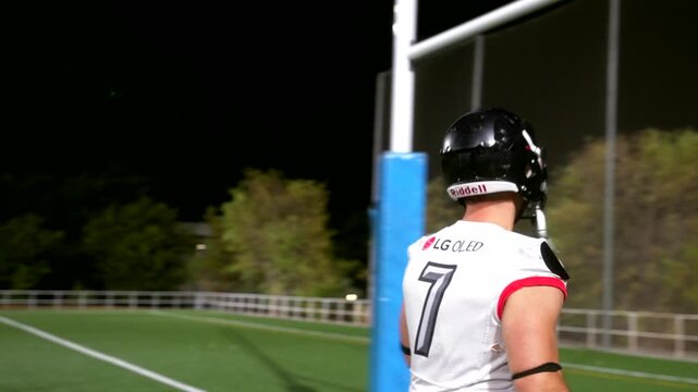 American football player scoring a touchdown at night