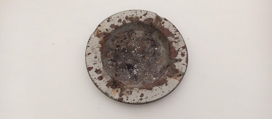 Dirty Used Ashtray with Cigarette Ash and Rust on White