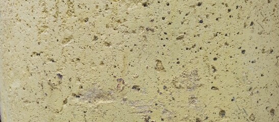 Yellow Porous Stone Wall Background Texture with Small Holes