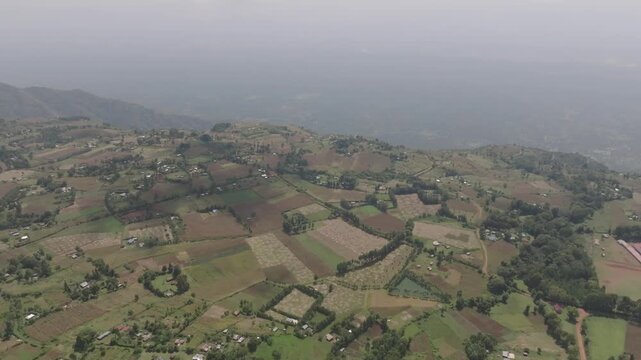 Aerial view of the patchwork of agricultural fields, with a scattering of buildings dotted across the landscape, Iten, Elgeyo-Marakwet County, Kenya.