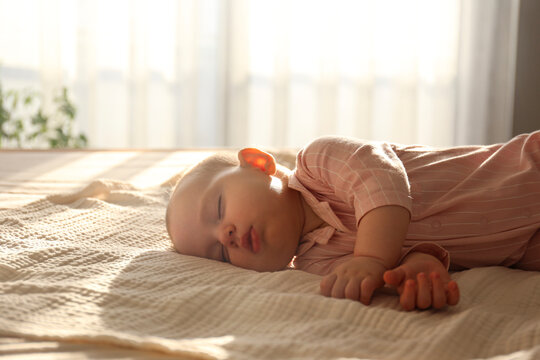 Adorable baby in pink pajamas sleeping peacefully. Copy space, background.