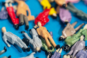 Miniature figurines create a vibrant disarray symbolizing social dynamics and diversity in a surreal urban crowd scene