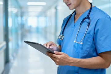 Doctor using tablet in hospital corridor