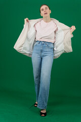 Professional photo collection of young European woman in light blazer with hair tied in ponytail and blue jeans on green chroma key background expressing different emotions and gestures perfect for ad