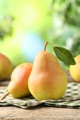 Fresh ripe pears on wooden table outdoors, closeup
