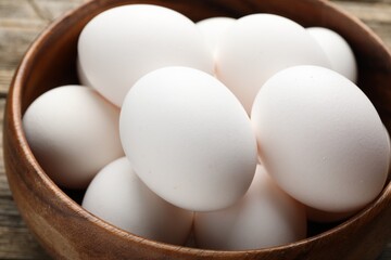 Fresh chicken eggs in bowl on table, closeup