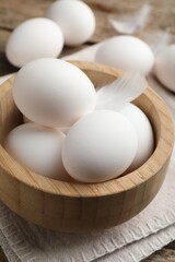 Raw chicken eggs in bowl on table, closeup
