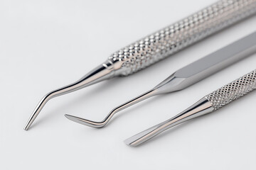 白背景に配置された歯科用ピンセットとスケーラーのクローズアップ