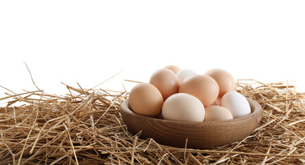 Raw chicken eggs in bowl on straw against white background. Space for text