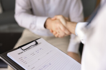 Close up medical worker and hospital patient shaking hands