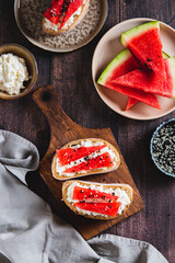Light crostini with ricotta and watermelon on a board on a table top and vertical view