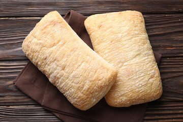 Freshly baked ciabattas on wooden table, top view