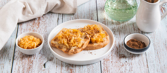 Appetizing croutons with stewed apple strips on a plate on the table web banner