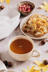 A cup of tea and autumn toast with apple jam on a plate on the table vertical view