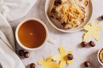Autumn tea in a cup with apple croutons on a plate on the table top view
