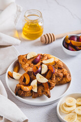 Croissant waffles with fruit and honey on a plate on a table vertical view