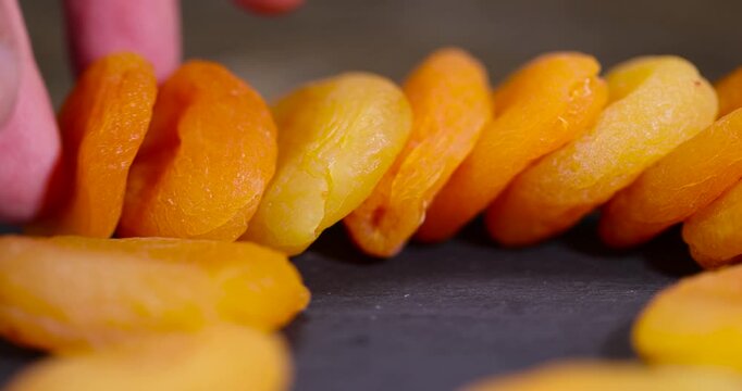 ripe orange apricot fruits on a black slate board, dried seedless pure dried apricots for long-term storage and used as a sweet or for making compotes