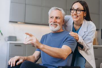 Caregiver assisting senior man in wheelchair pointing finger, looking away