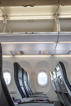 Airplane overhead luggage compartments closed and illuminated, showing modern cabin design and organized interior space for commercial aviation