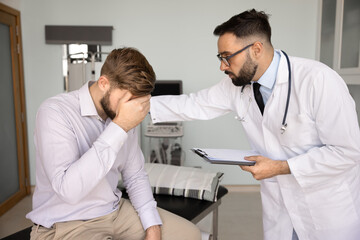 Fototapeta premium Empathetic male physician doctor comforts worried patient