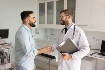 Obraz premium Therapist holding clipboard, shake hands with clinic client