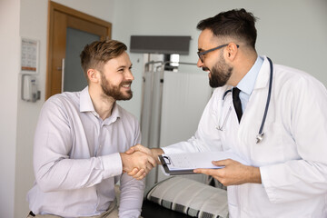 Fototapeta premium Handshake between satisfied patient and qualified male doctor