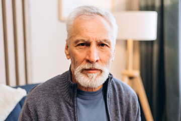 Senior man with gray beard looking at camera