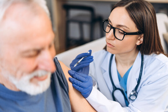 Doctor vaccinating senior man during medical appointment