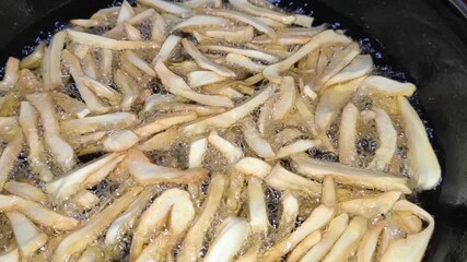 Step-by-step frying of jackfruit chips in a large bowl, capturing the vibrant colors and textures of each stage. Perfect for food lovers and cooking enthusiasts seeking traditional crispy snack 