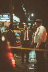 Detective discusses investigation with police officers at night in urban area