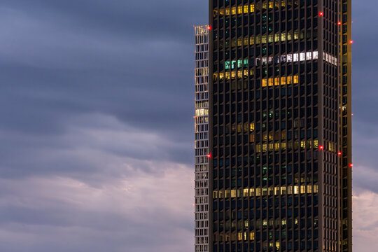 Office tower fa&ccedil;ade with reflections of sunset light in Frankfurt, representing connection between architecture, business and contemporary urban design