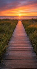 Obraz premium Wooden boardwalk leads to a serene beach at sunset with vibrant colors