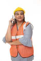 Digital India. Female constructor talking on mobile phone. Wearing hardhat and worker apron while isolated on white studio background.