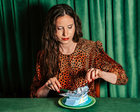Portrait of person cutting money on plate in humorous capitalist scene