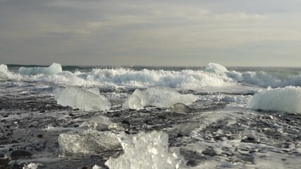 Chunks of glacier ice resting on volcanic black sand at Black Diamond Beach in Iceland.