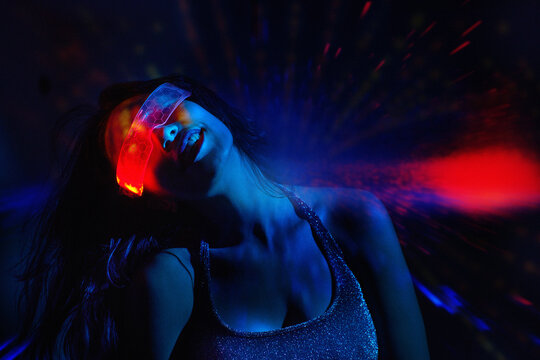 Person dancing in nightclub with VR set and neon light effect